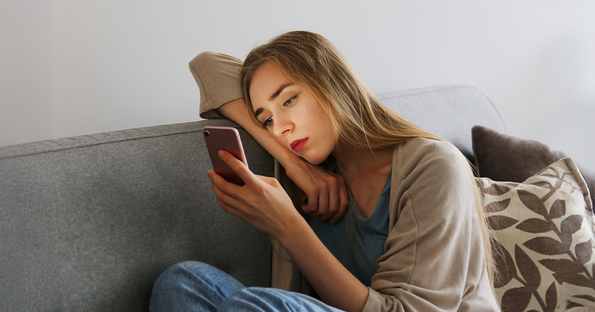 Young woman looking at her cell phone researching pregnancy options
