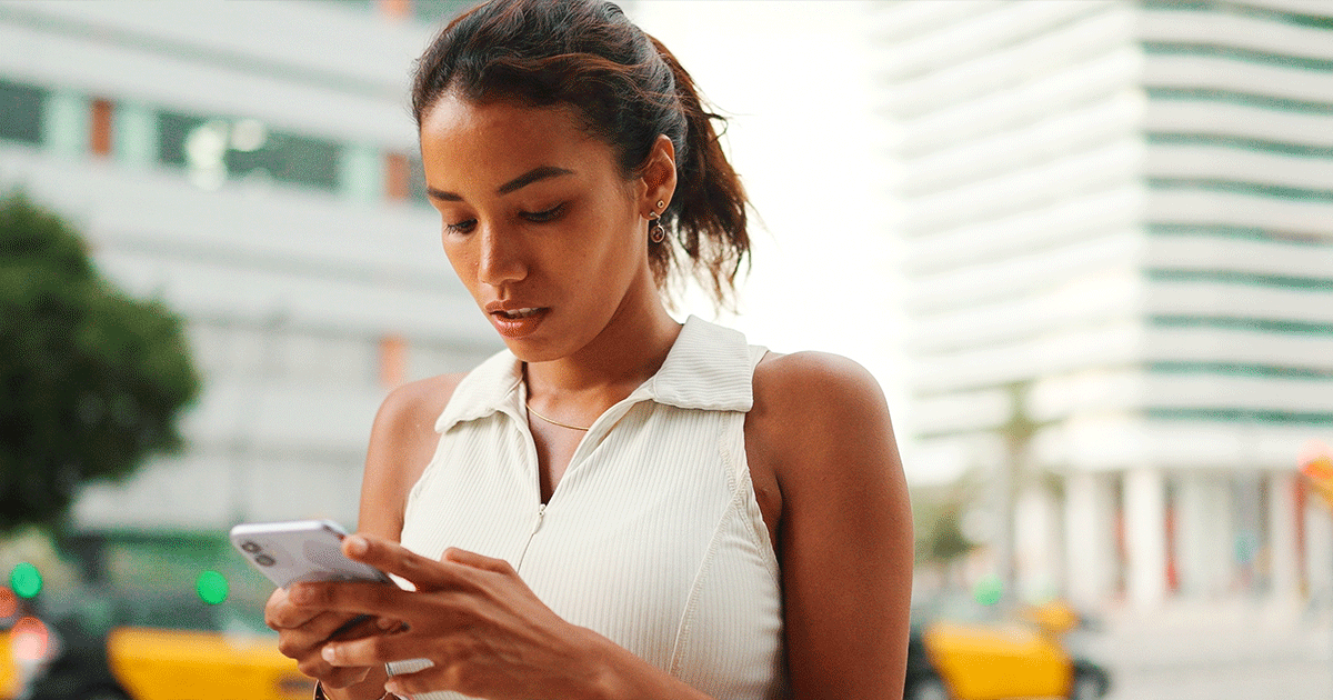 A young woman uses her phone to research medical and surgical abortion procedures.
